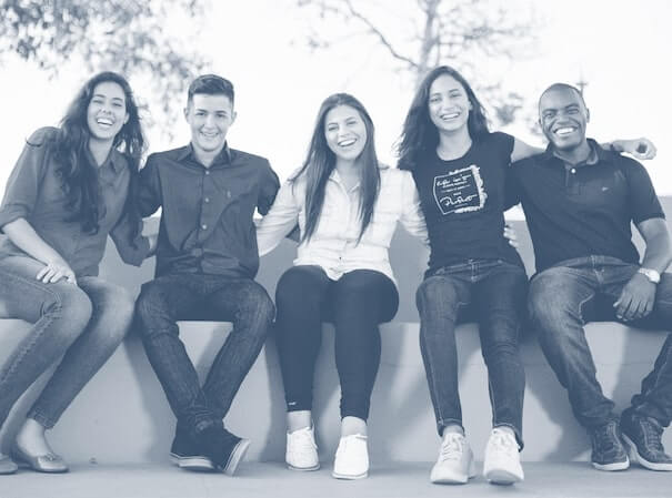 Coworkers sitting together and smiling outside.